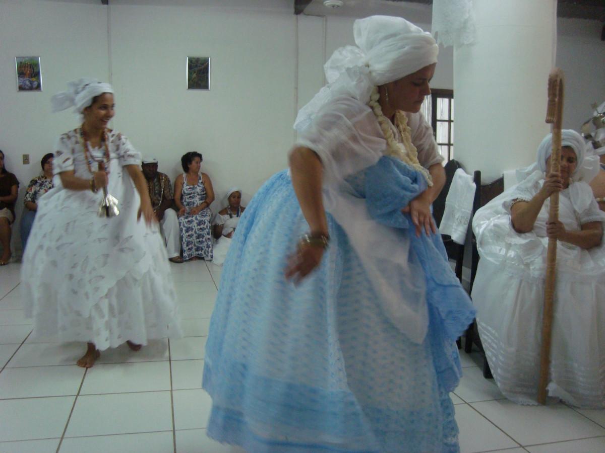 <em>Iâo</em> wpada w trans, a <em>equede</em> zawiązuje mu na pasie dla bezpieczeństwa białą przepaskę, która ma „ograniczać” bóstwo. Autor: Piotr Brych, Serra, 2012.