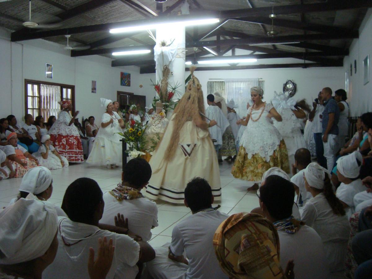 Oxum (w ciele mężczyzny) oddaje dziecko matce, błogosławiąc je. Autor: Piotr Brych, Serra, 2012.